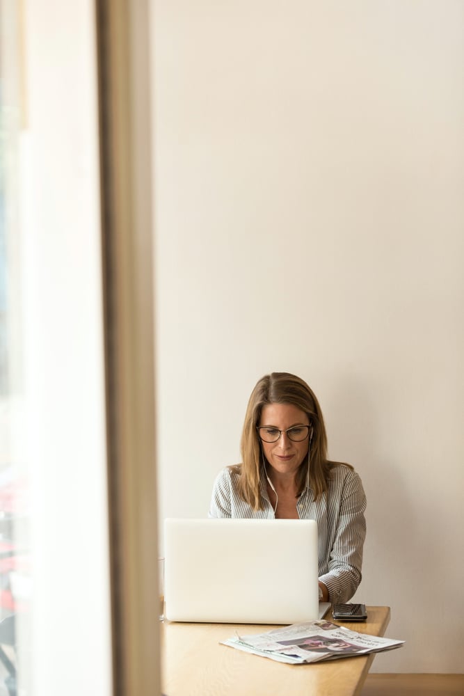 woman sitting at a table working on a laptop